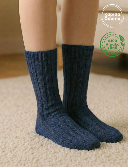 Lacivert örgü %100 alpaka yünü çorap giyen ayaklar, bej halı üzerinde